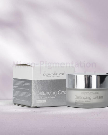 a short cylindrical container with a silver lid, a matching packaging container next to it 