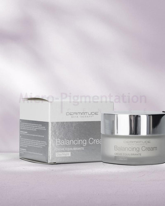 a short cylindrical container with a silver lid, a matching packaging container next to it 